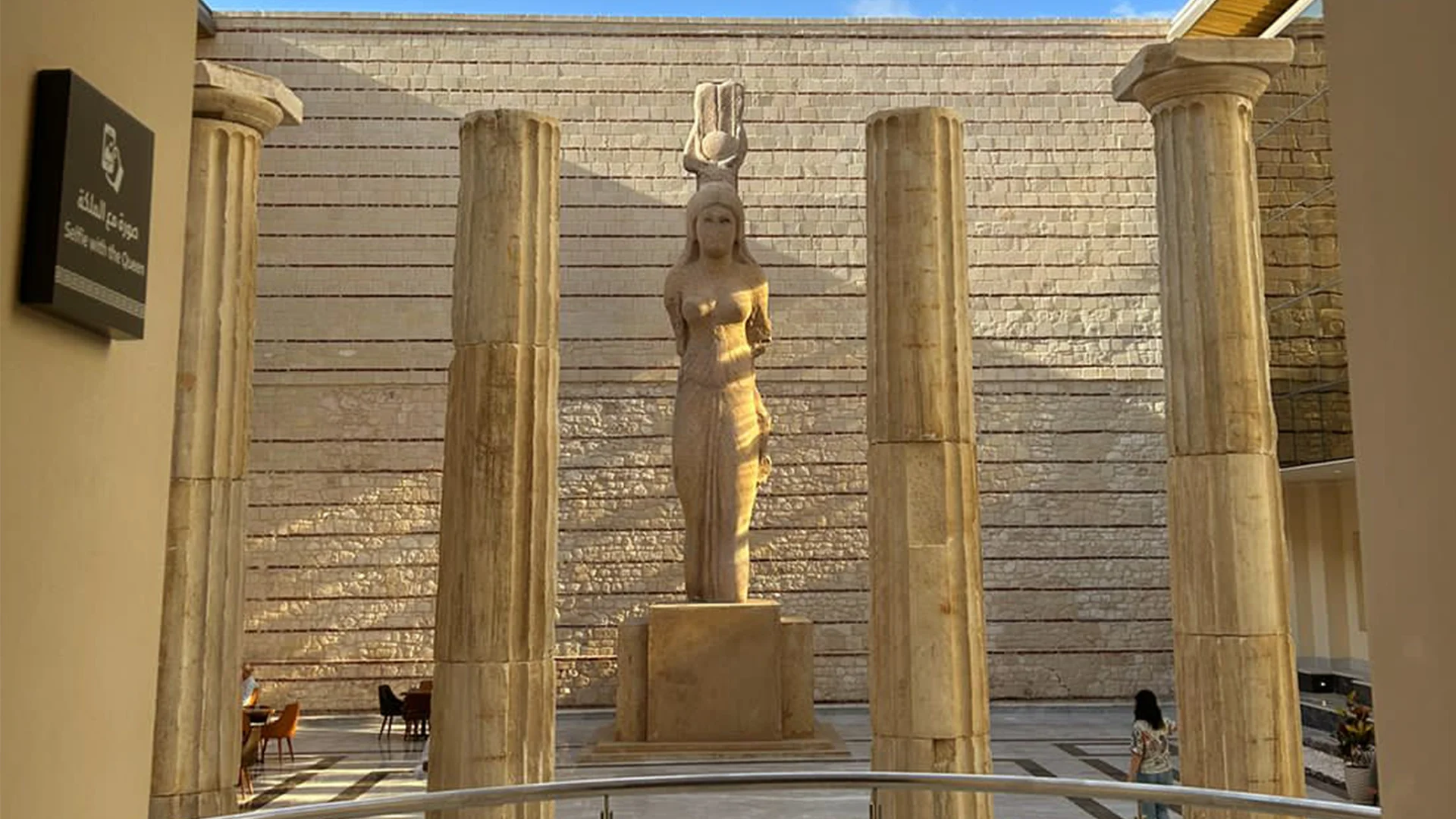 A classical statue displayed between ancient stone columns inside the Alexandria Roman Museum, showcasing the rich historical heritage of Alexandria.